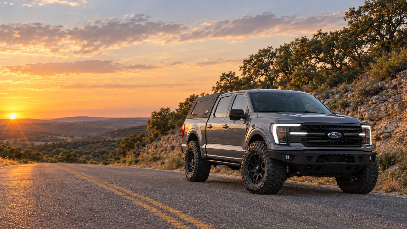 2025 Ford F-150 with a BDS 2.5-inch FOX leveling kit, Fuel wheels, Nitto Ridge Grappler tires, ADD bumpers and a Rough Country bed cap on a Texas Hill Country road